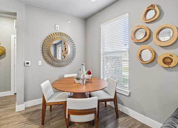 A dining room with a round table and chairs.