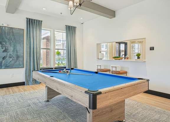A pool table in a room with a painting on the wall.