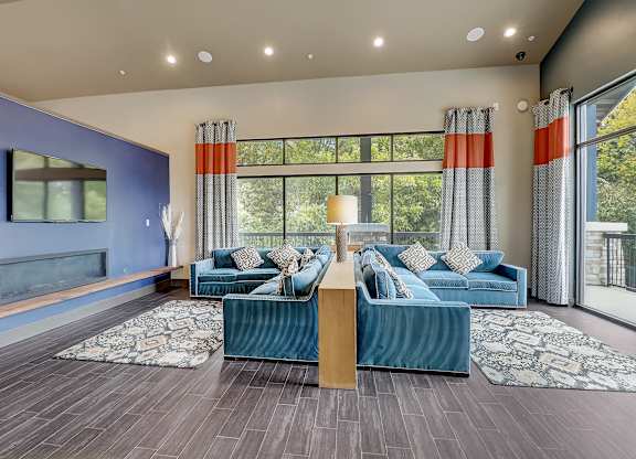 a living room with blue couches and a large window