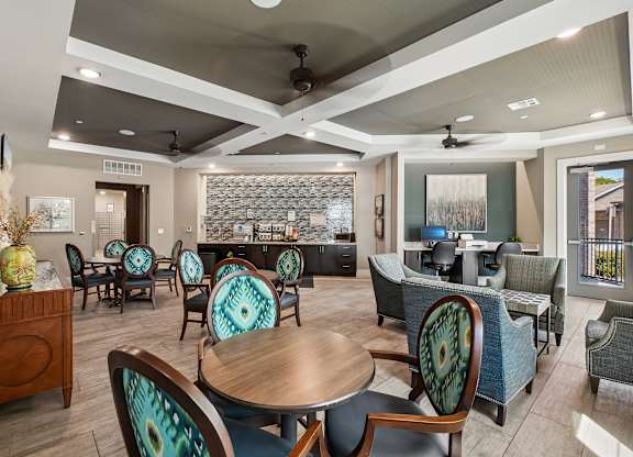 A modern dining room with a glass backsplash and patterned chairs.