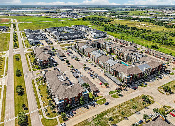 A bird's eye view of a residential area with multiple houses and cars.