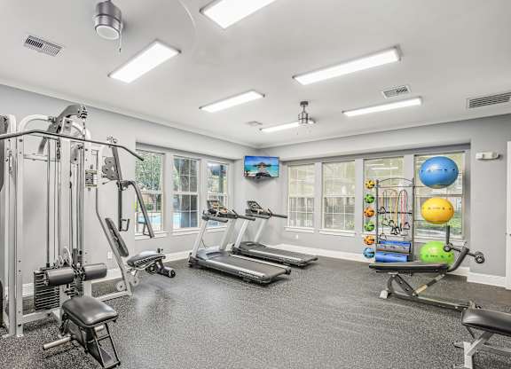 A spacious gym with a variety of equipment including treadmills, weights, and exercise balls.