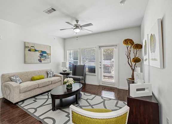 A living room with a couch, coffee table, and a painting on the wall.