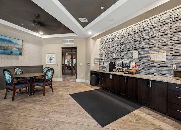 A stone wall with a counter and chairs in front of it.