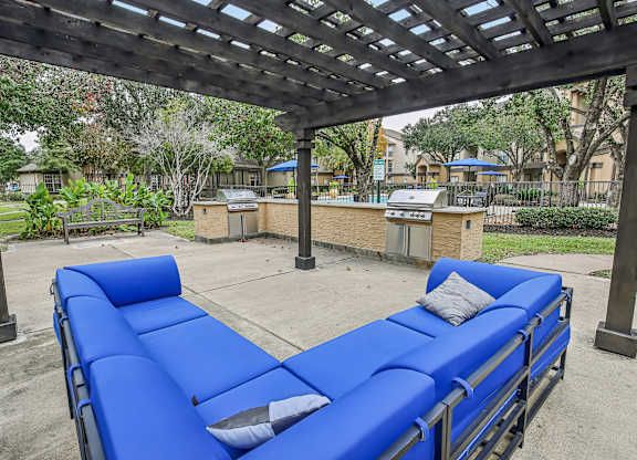 A blue lounge chair under a wooden pergola.