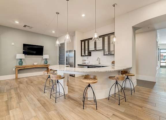 A kitchen with a bar area and a television.