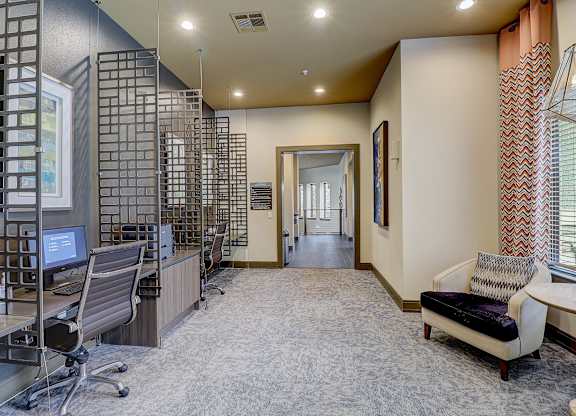 a large office with a desk and chairs and a computer