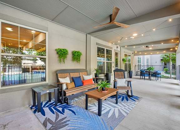 A patio with a table and chairs and a fan.