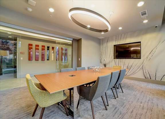 A conference room with a long table and chairs.