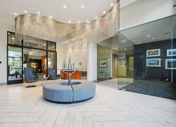 A modern lobby with a circular blue and white patterned rug in the center.