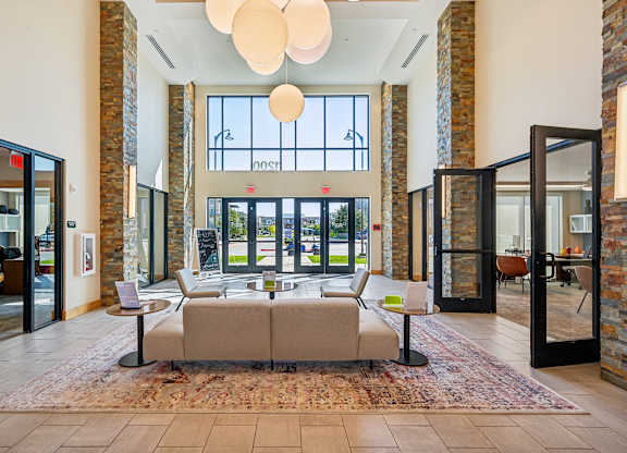 A hallway with a large rug and a couch.