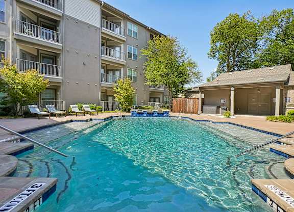 A swimming pool in front of apartment buildings.