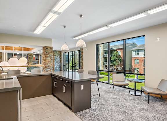 A modern kitchen with a large island and a view of the backyard.