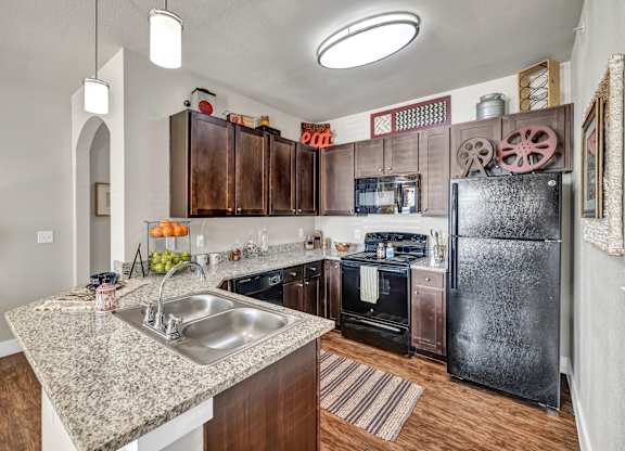 A kitchen with a sink, refrigerator, and oven.