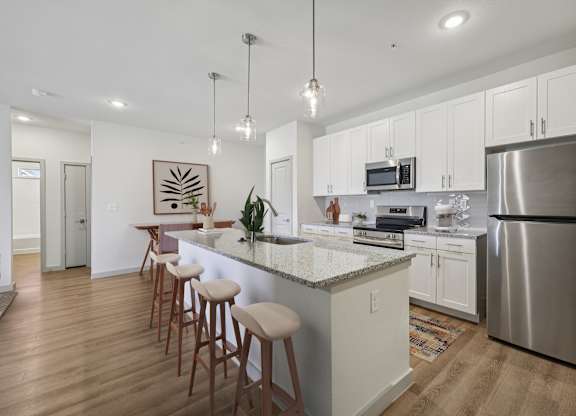 A kitchen with a bar area and stools.