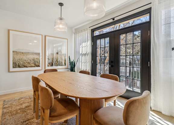 A dining room with a wooden table and chairs.