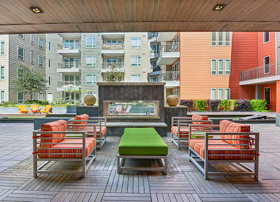 A patio with a table and chairs is surrounded by buildings.