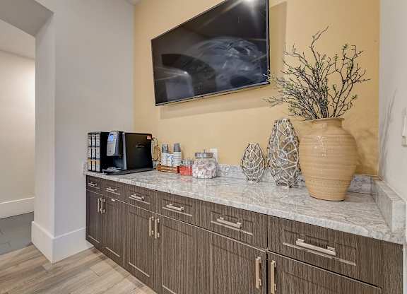 A kitchen with a counter, a microwave, and a vase.