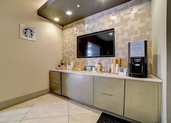 A wall with a Starbucks sign and a TV on it.