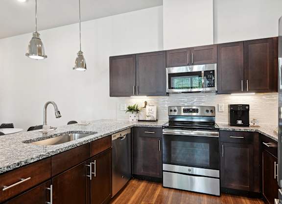 an apartment kitchen with stainless steel appliances and granite counter tops
