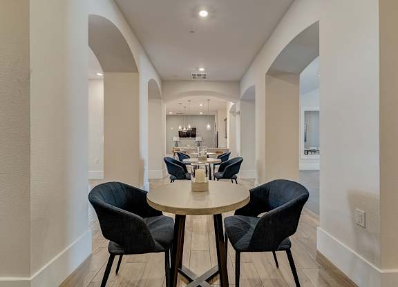 A dining room with a round table and chairs.