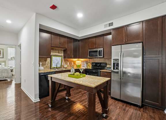 A kitchen with a table and a fridge.