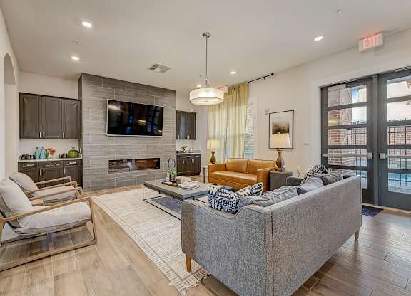 A modern living room with a grey couch, a fireplace, and a flat screen TV.