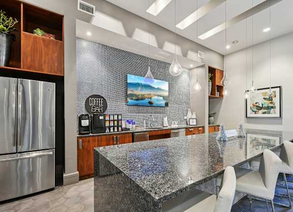 A modern kitchen with a granite countertop and a bar area.