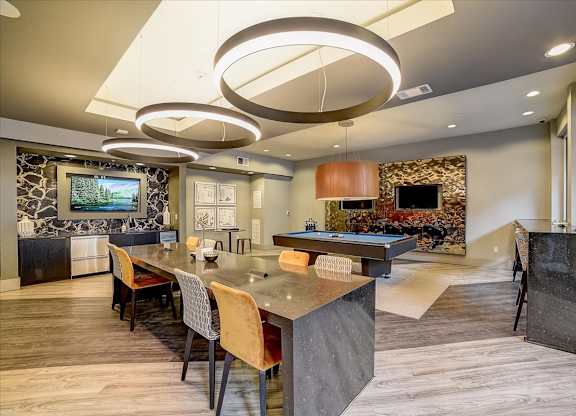 A modern kitchen with a long island and chairs.