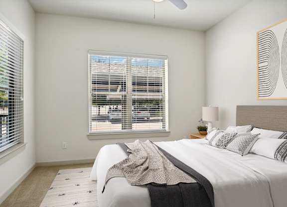 a bedroom with a large bed and two windows