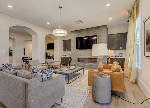 A modern living room with a grey sofa and a glass coffee table.