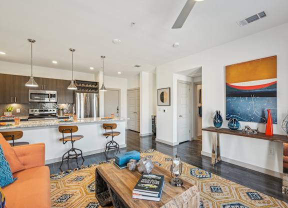 A living room with a kitchen area in the background.