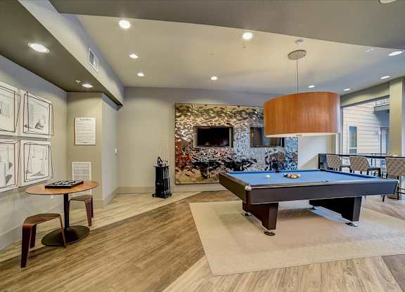 A room with a pool table and a fireplace.