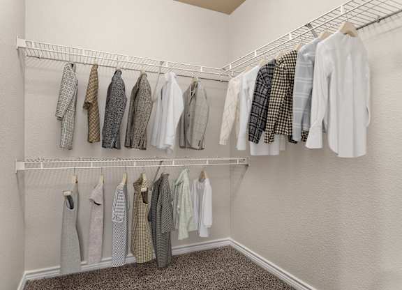 Walk-in closet with double hanging rods, wire shelving, and carpeted floor.