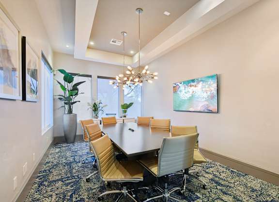 A conference room with a large table and chairs.