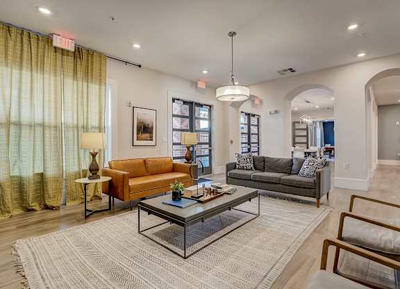 A living room with a glass coffee table in the middle.