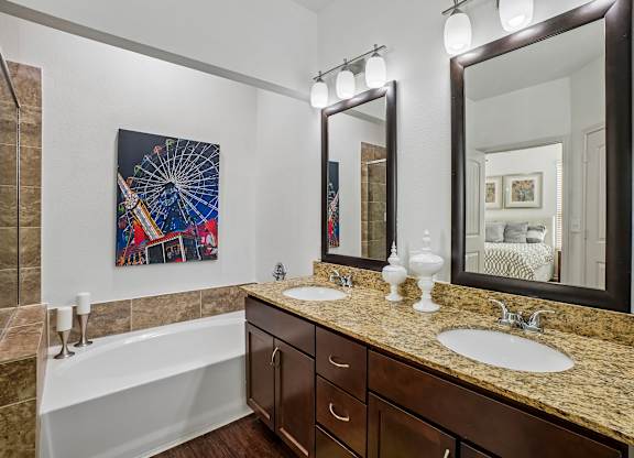 A bathroom with a large mirror and a painting on the wall.