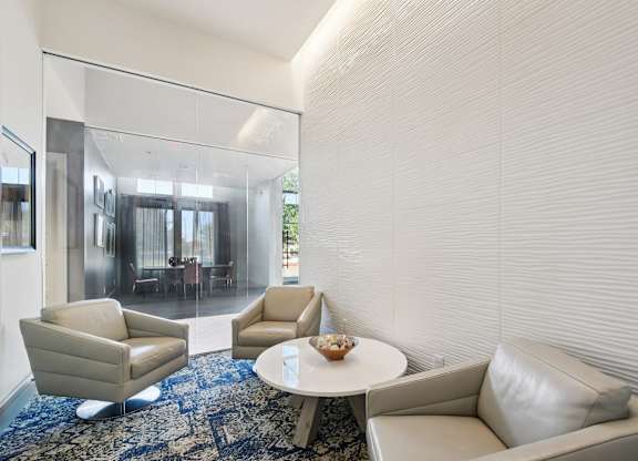 A living room with a white couch, two chairs, and a coffee table.