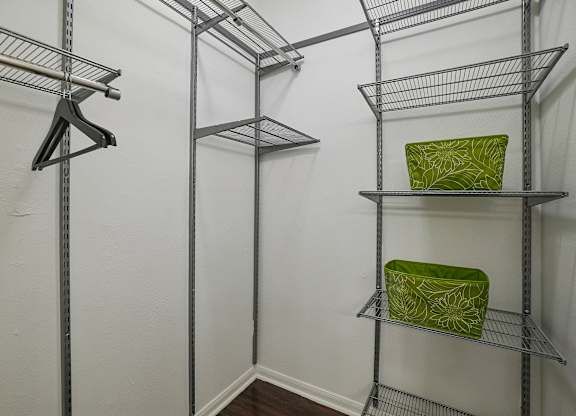 A white wall with a shelf and a green bag on it.