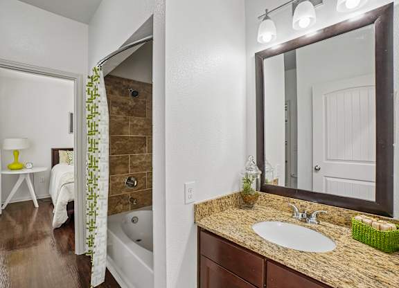 A bathroom with a brown tub and a white sink.