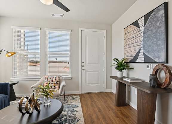 A living room with a brown table and a painting on the wall.