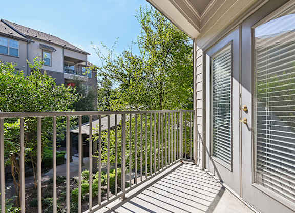 the view from the balcony of a home with a door to the yard