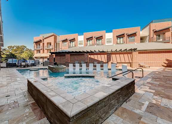 A pool with a hot tub in the middle of it.