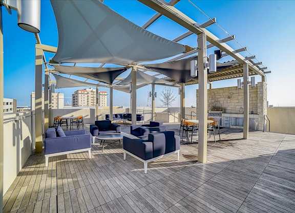 A rooftop patio with a white canopy and wooden deck.