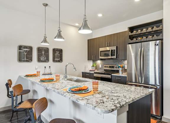 A kitchen with a marble countertop and a refrigerator.