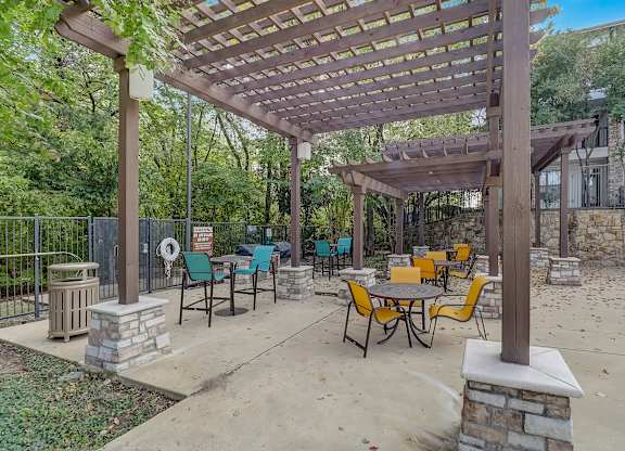 a patio with tables and chairs and a pergola