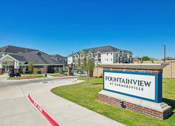 A sign that says Fountainview at Farmersville in front of some houses.
