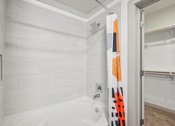 A white bathroom with a white tub and a white shower.