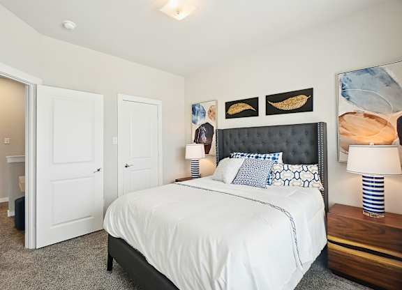 A bedroom with a large bed and a painting on the wall.