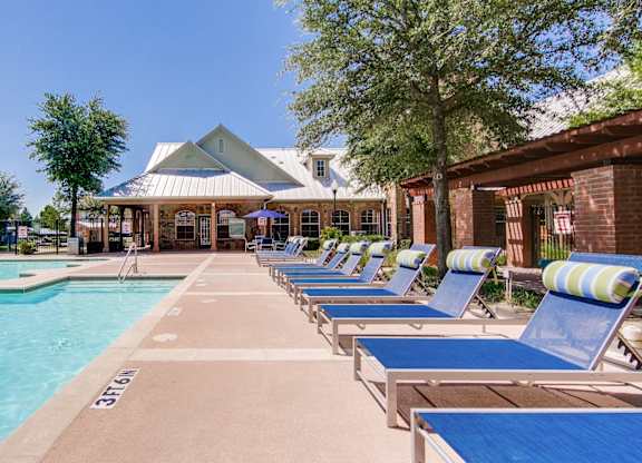 the preserve at ballantyne commons pool with chaise lounge chairs and a building